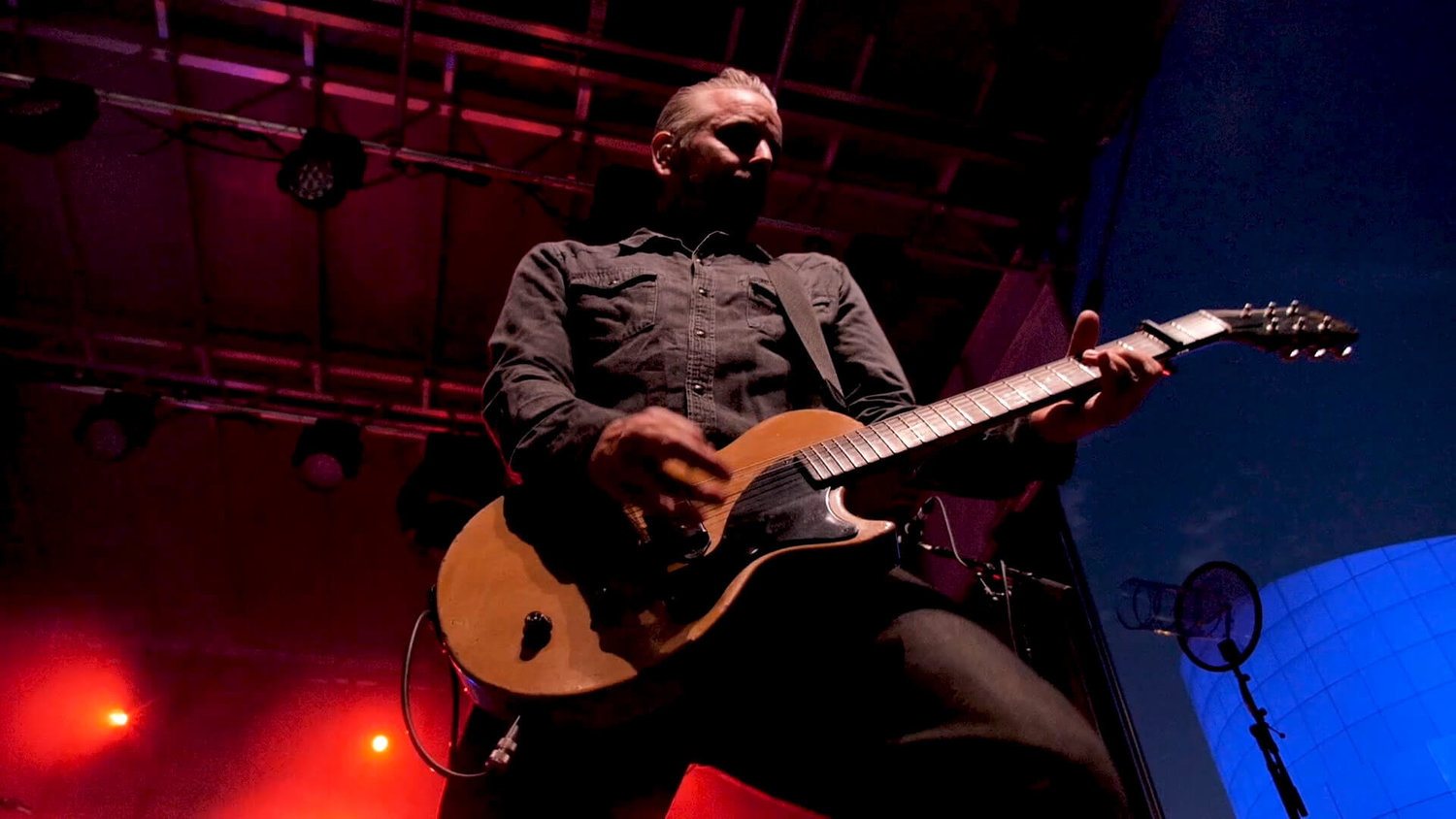 image of man playing guitar at a concert